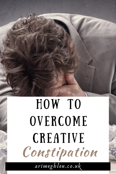 Photo of a man in a grey suit, with his face in his hand