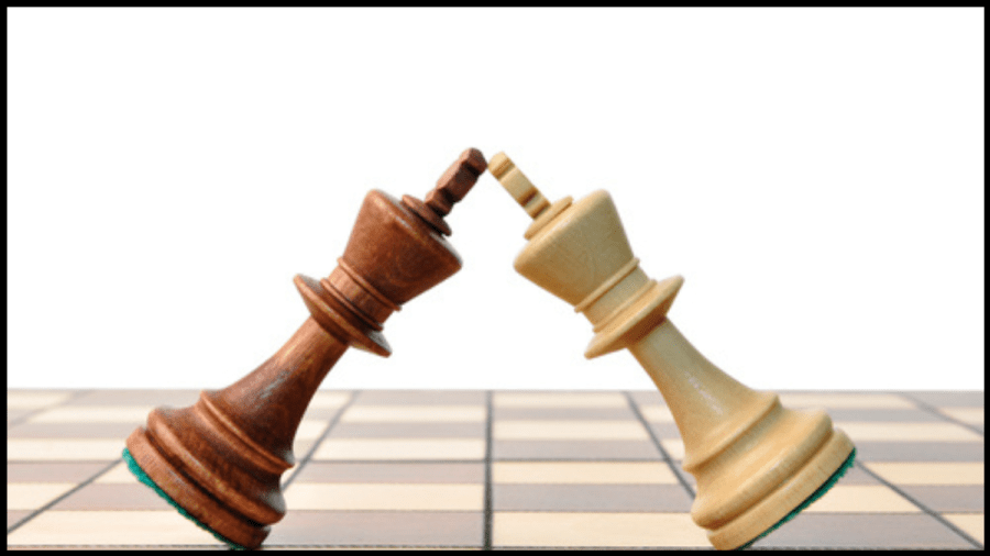 Photo of two chess piece Kings going head to head on a chess board.