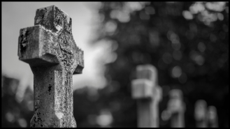 Close up black and white photo of a cross grave.