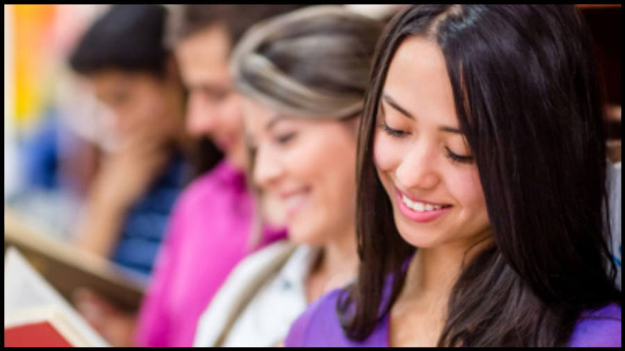 Photo of several people in a line, reading books.