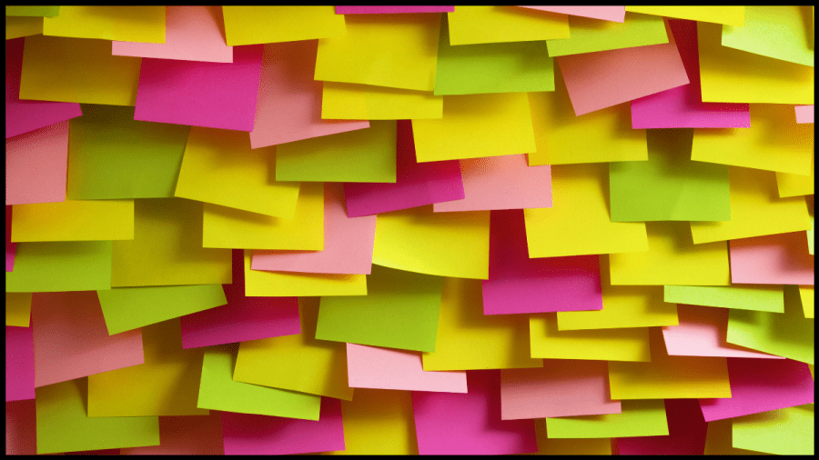 Photo of multiple brightly coloured blank post it notes in green, yellow and pink
