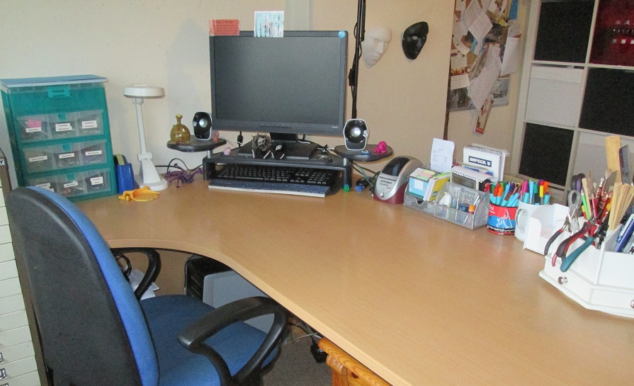 Image: Ari Meghlen's writing desk with monitor, keyboard and cups of stationery.