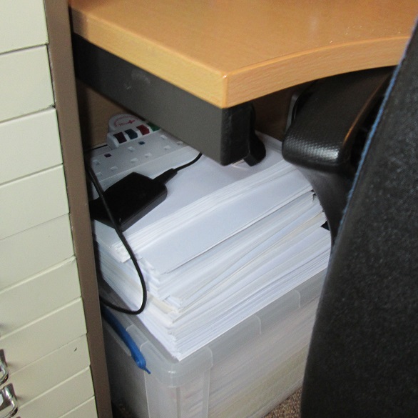 Image: Ari Meghlen's writing desk. Stack of scrap paper under the desk