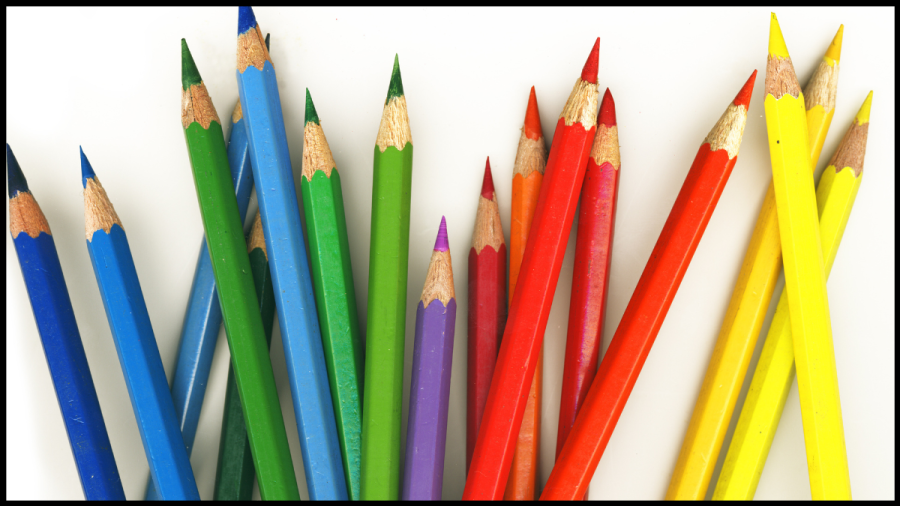 Photo featuring a selection of coloured pencil crayons against a white background. T