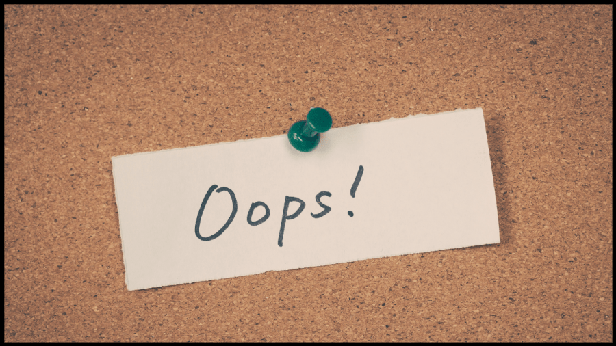 Photo of a slip of paper pinned to a cork board with the word Oops! written across it.