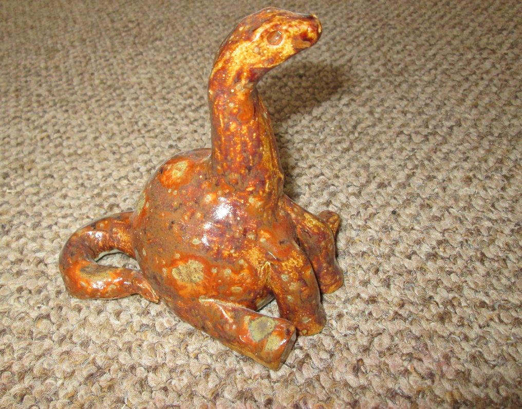 pottery sculpture of an apatosaurus sitting