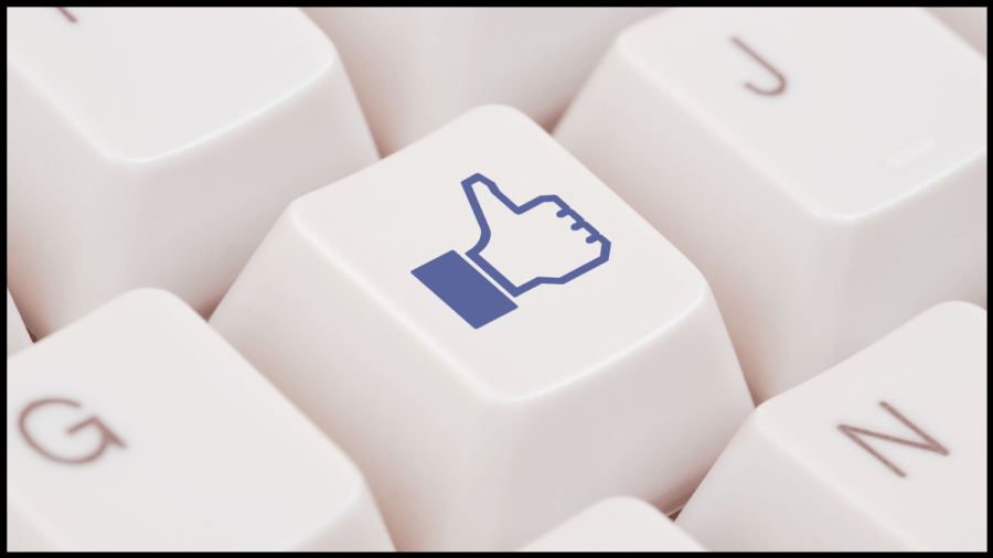 Close up photo of a computer keyboard key with the image of a thumbs up on it, to represent the Facebook "like"