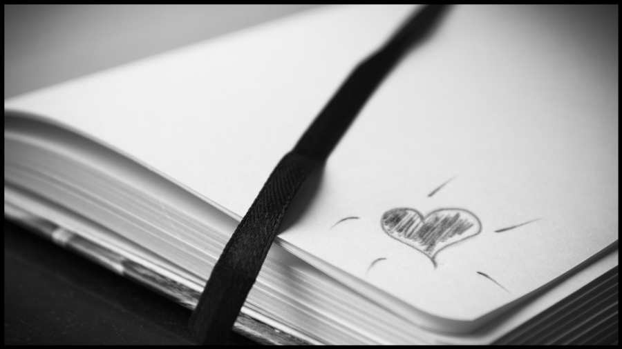 Close up photo of a scribbled heart on the corner of a notepad.