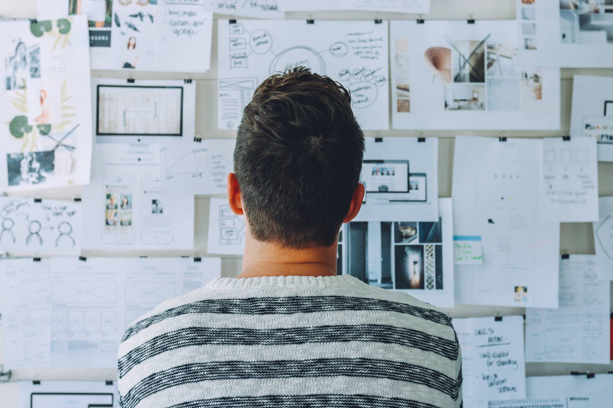 Have a plan. Man standing before a noticeboard of notes