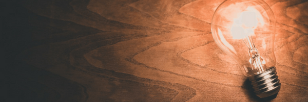 Image: Lightbulb lying on wooden floor, lit.