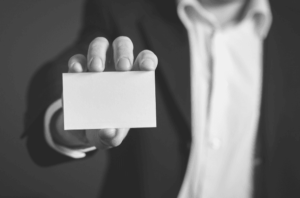 Featured Images - Man holding out a business card. Using business cards in your marketing
