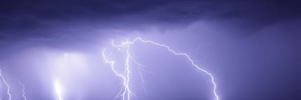 Image: Purple sky lit by lightning strike. Lightning storm