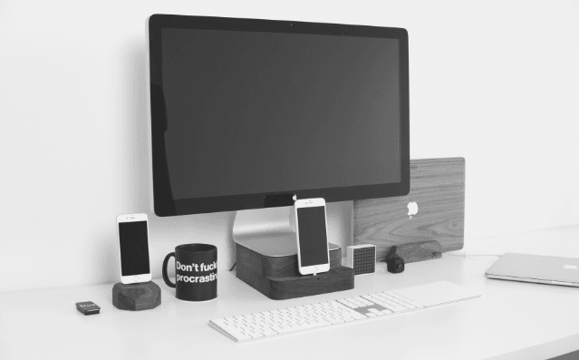 Featured Image - monitor screen, mobile phone and a cup with Dont fucking procrastinate on a desk.