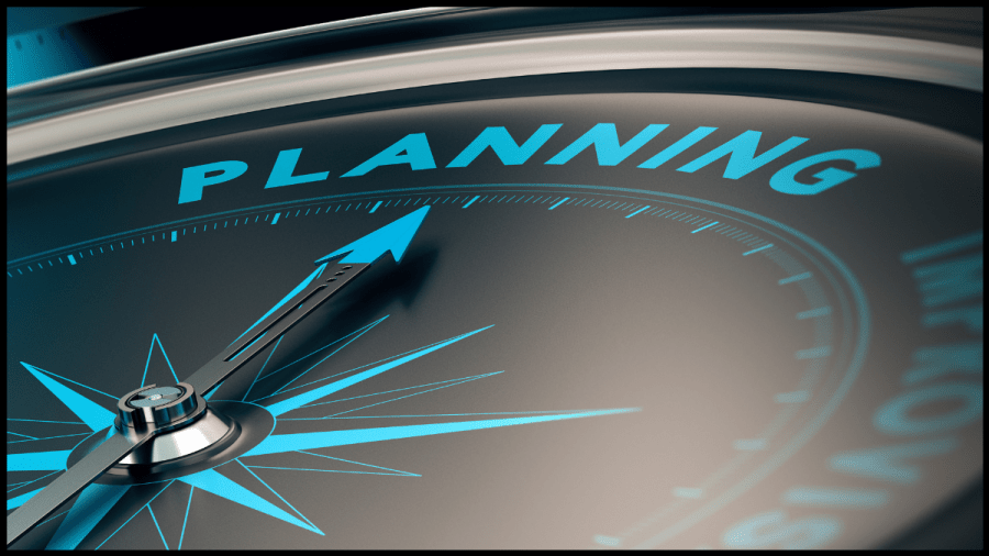 Image of a black compass with bright blue markings and at north it says "planning"