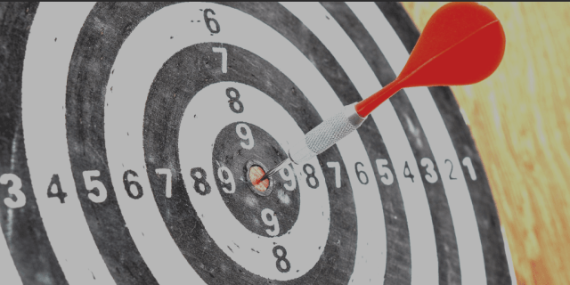 Photo of a target with a dart in the bullseye