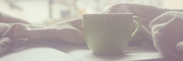 Coffee cup resting on a book, warm blanket. Relax, read, chill. Image from pixabay