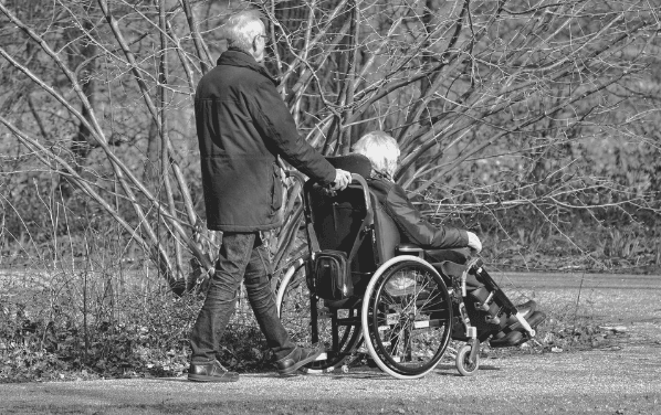 Featured Image - man pushing a wheelchair. Image from Pixabay