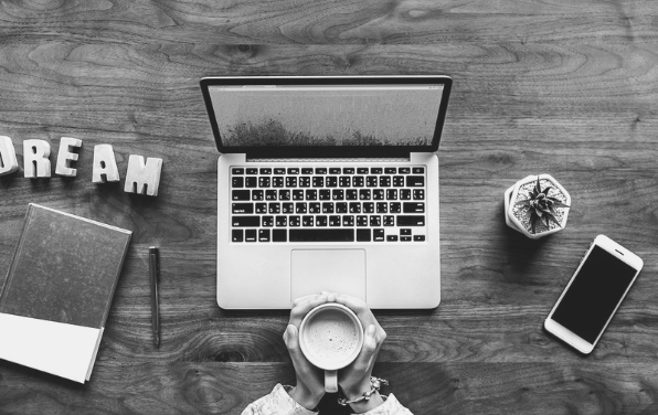Featured Image for Ike Pius guest post. Image of laptop on desk with person holding a mug, from Pixabay