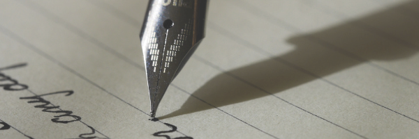 Close up photo of a fountain pen nib writing on paper. Image from Pixabay