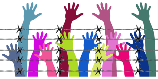 Human Rights image. Hands raised above barbed wire. Image from Pixabay