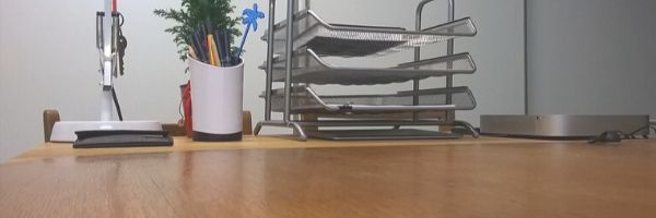 Photo of a desk with pen pot and paper trays