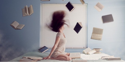Blog Image - Woman knelt on a bed and books flying around her. Image from Pixabay
