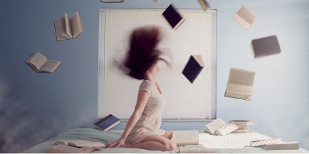 Blog Image - Woman knelt on a bed and books flying around her. Image from Pixabay