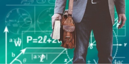 Blog Image - Cropped photo of a man holding a book, carrying a satchel and standing before a chalkboard covered in equations.  Image from Pixabay