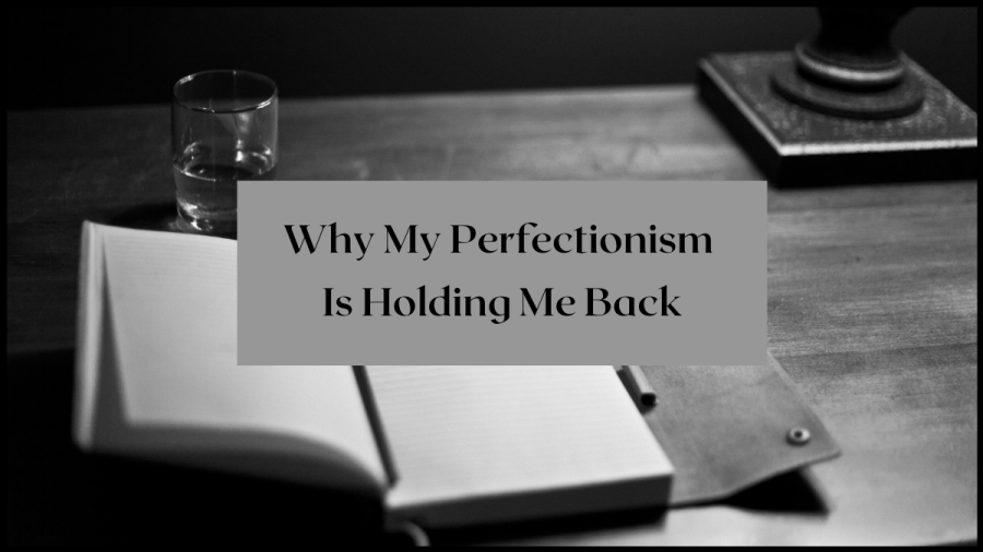 Why my perfectionism is holding me back. Image from Canva, black and white photo of a desk, notepad, glass.