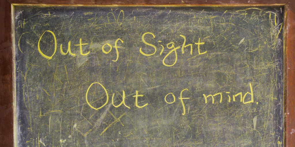 Image of a chalkboard with the words written on it reading Out of Sight, Out of Mind. Image from Canva Pro