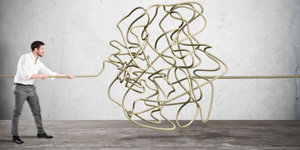 Image of a man holding a rope that becomes a tangled mess in the middle. Image from Canva Pro