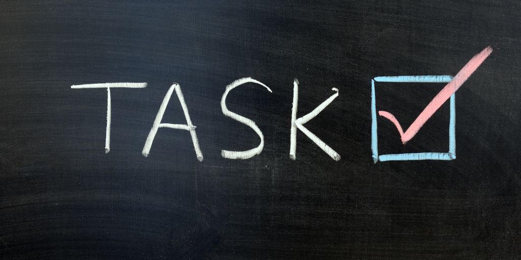 Image of the word "Task" with a tickbox on a chalkboard. Image from Canva Pro