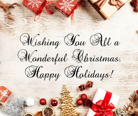 Image of wooden floor with beautifully decorated presents and baubles around the edge, text in the centre reads "Wishing You All a Wonderful Christmas. Happy Holidays!"