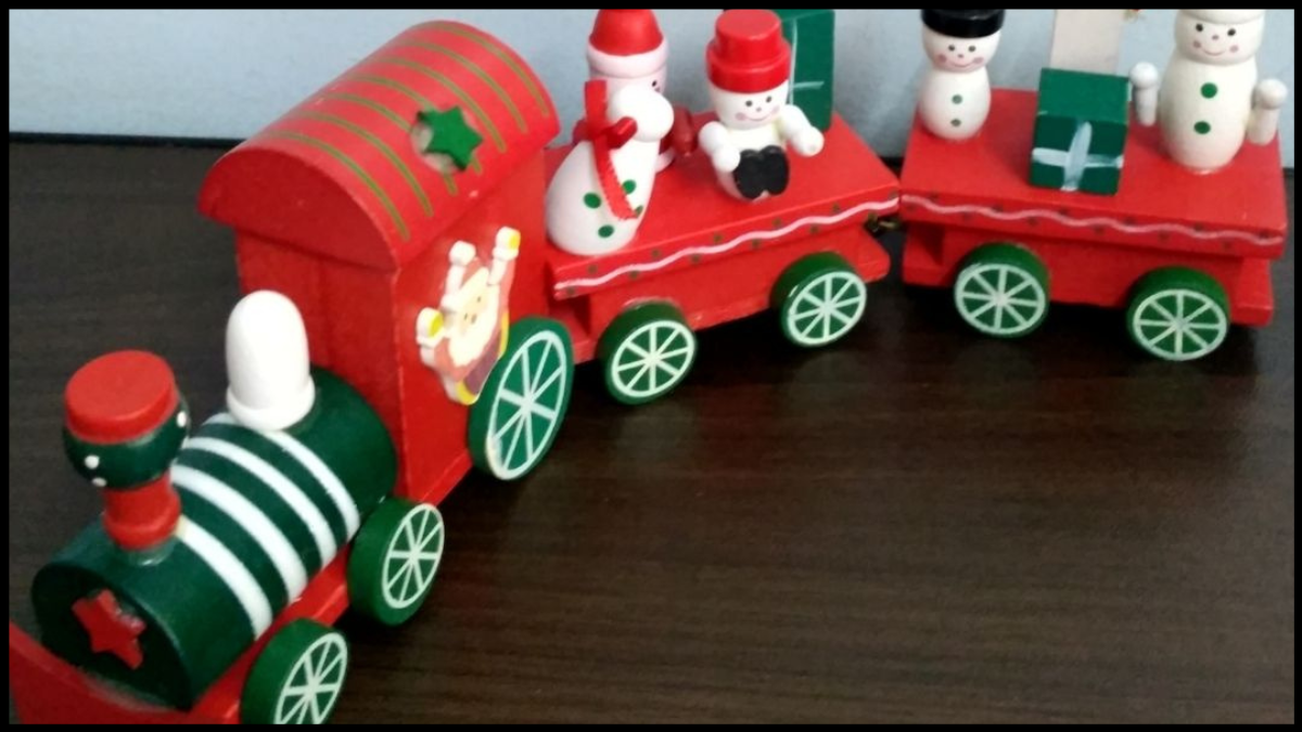 Photo of a green and red wooden toy Christmas Train with little wooden snowmen riding it