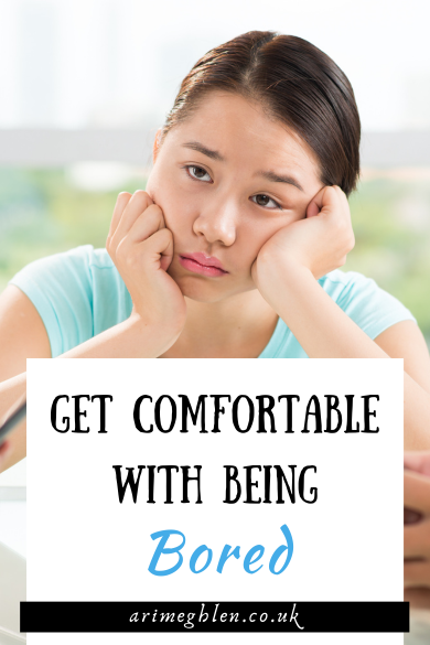 Photo of a young woman in a blue t-shirt, looking bored. Text overlay reads: Get Comfortable With Being Bored. AriMeghlen.co.uk
