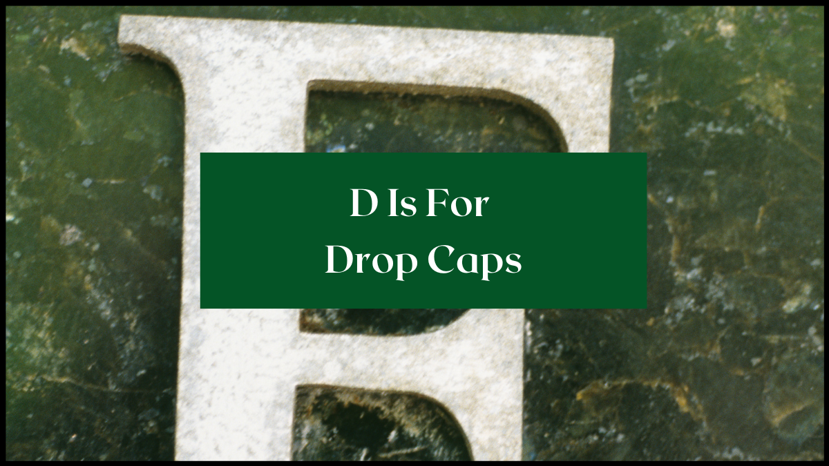 Large white E on a green marble background. Text overlay reads D is for Drop Caps.
